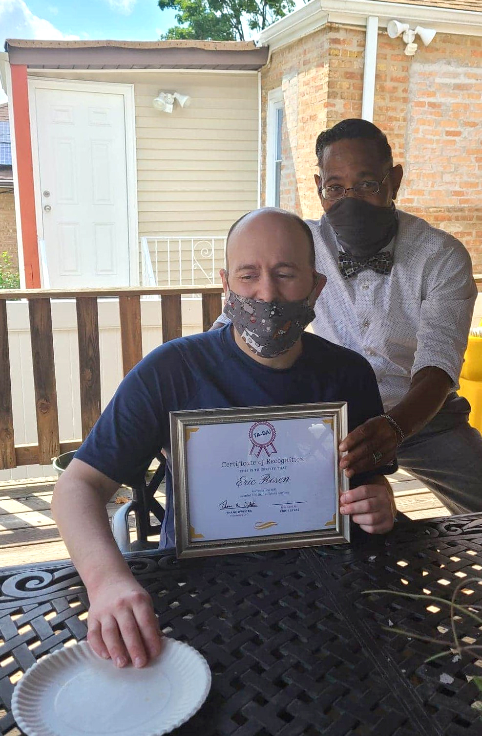 Picture of man holding up award posing with other man