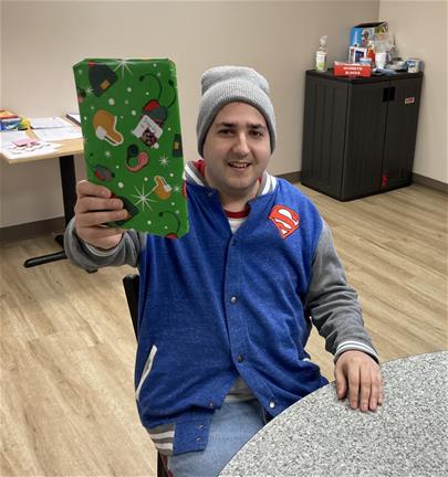 Man holds up a wrapped Christmas present