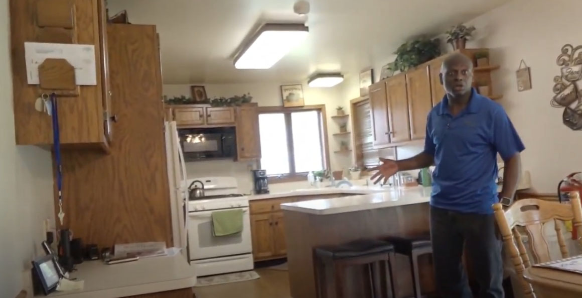 Image of man giving tour of home in kitchen